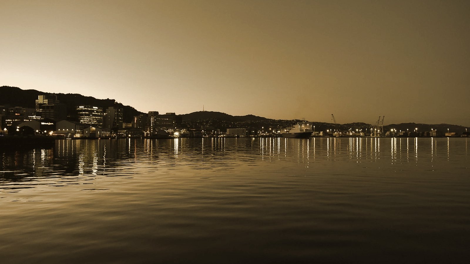 Wellington harbour at dusk, city lights reflecting on calm water